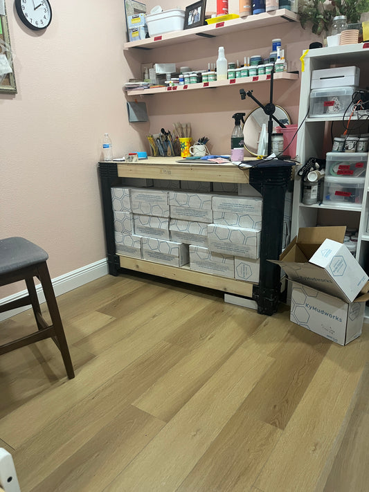 Craft table organized with pottery and craft materials.