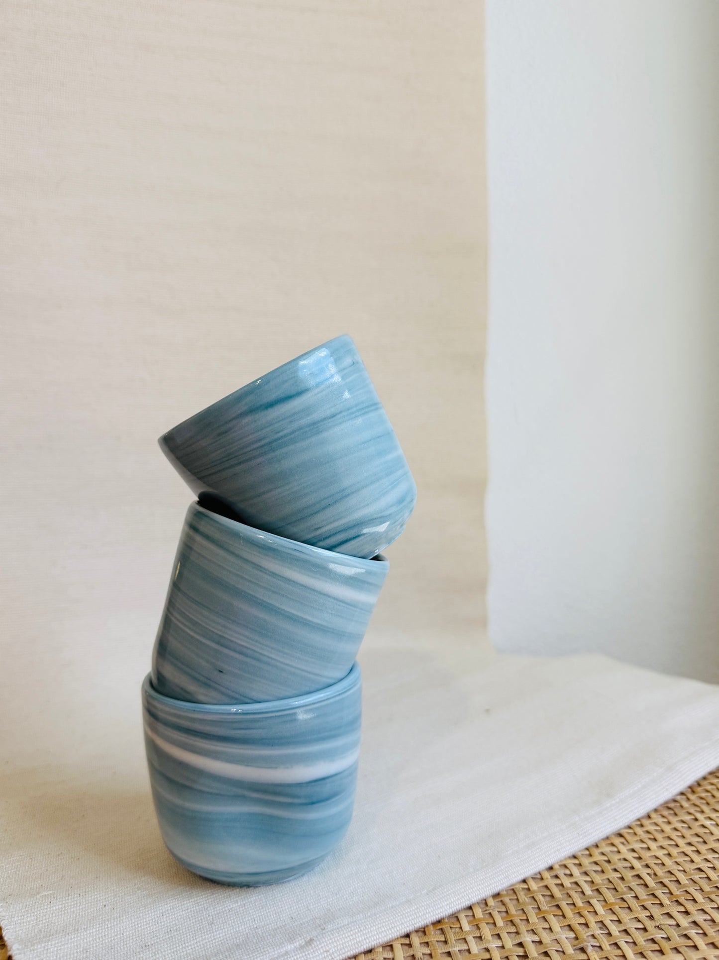 Stack of blue ceramic bowls on a white surface with a neutral background