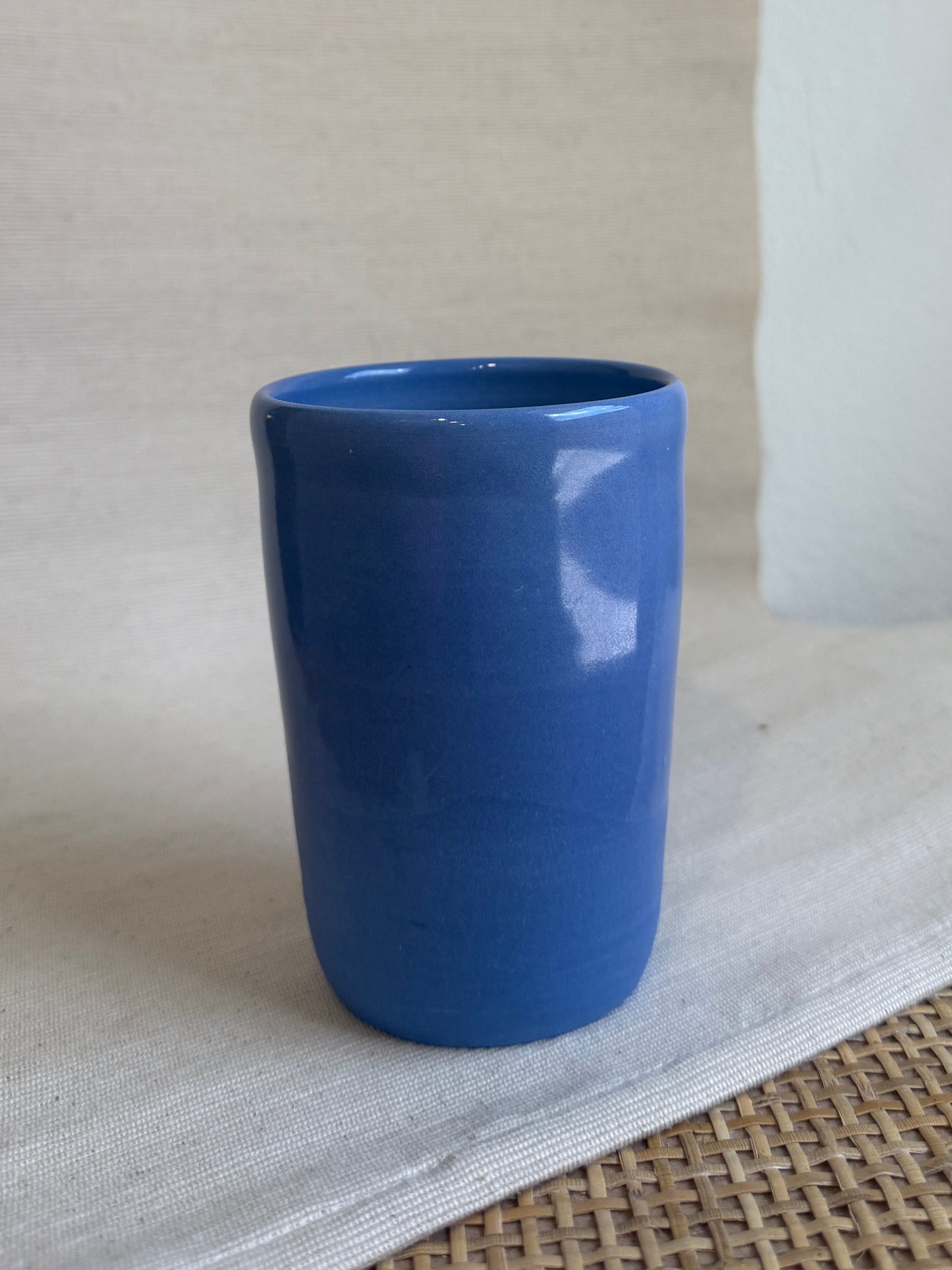 Blue ceramic cup on a textured surface with a neutral background