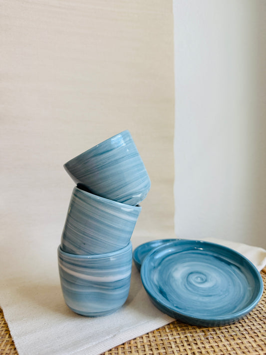 Stack of blue ceramic bowls on a white surface with a neutral background