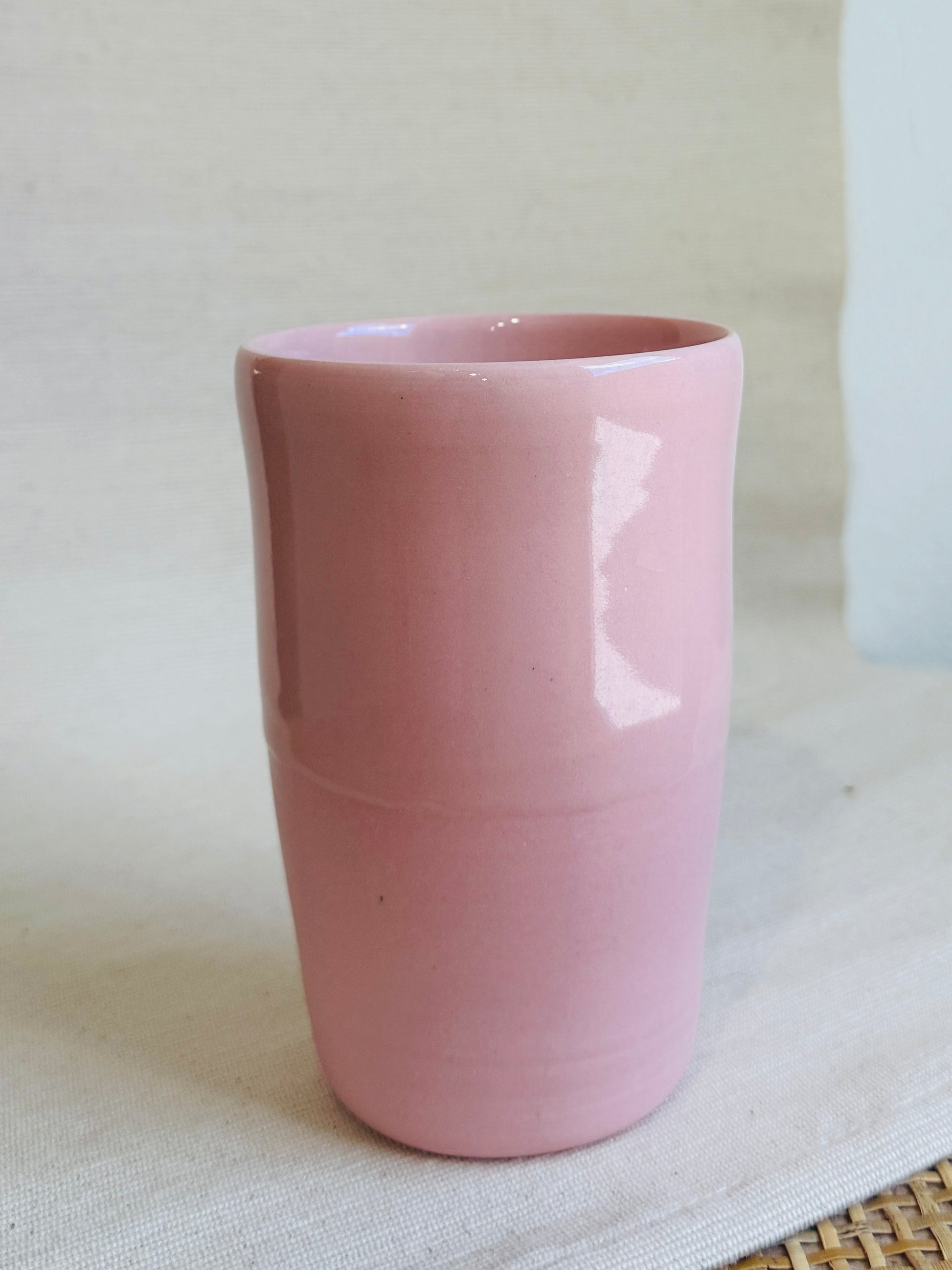 Pink ceramic cup on a light surface
